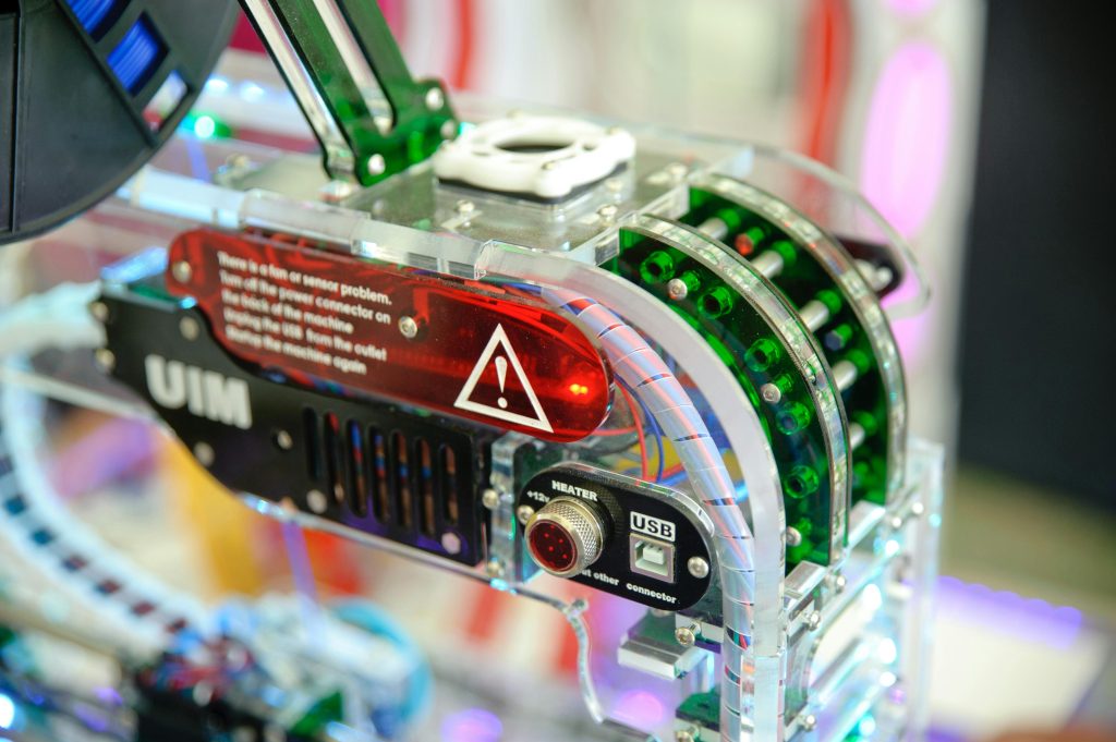Close-up of an electronic manufacturing process showcasing circuit components, transparent casing, and a warning label, emphasizing the importance of DFM.