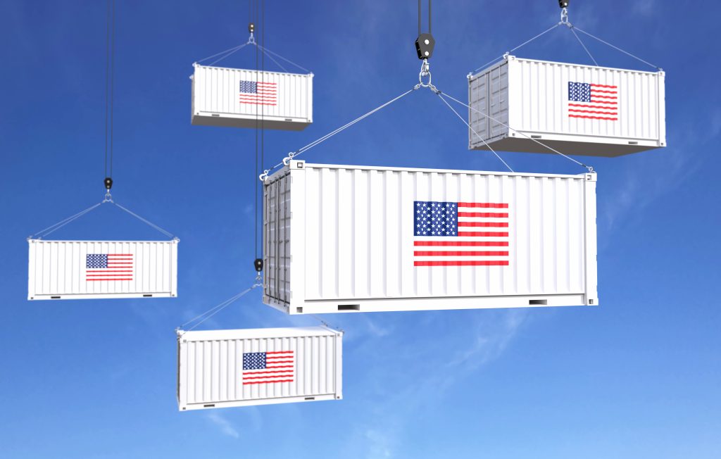 hipping containers with American flags being transported, symbolizing the reshoring of manufacturing to the United States.